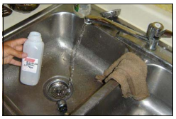 A person taking a water sample from a sink