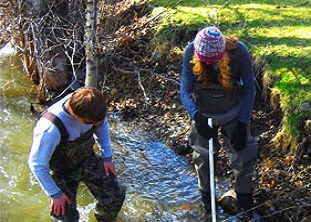 two people collecting water qualitydata in the field